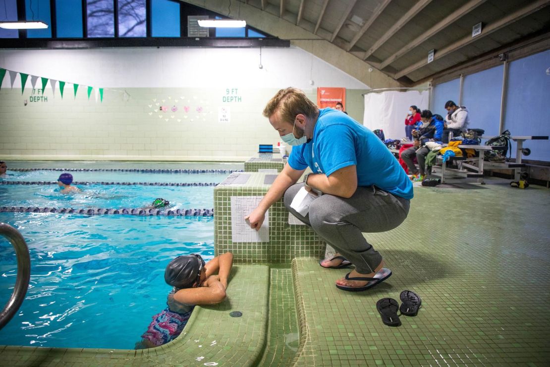 swim coach reviewing workout with swimmer.